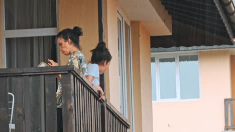 girls using phone on balcony