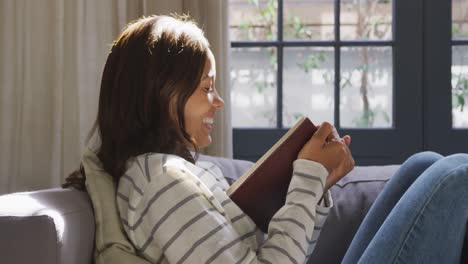 Mixed-race-woman-reading-a-book.-Social-distancing-and-self-isolation-in-quarantine