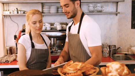 waiter and waitress using digital tablet at counter