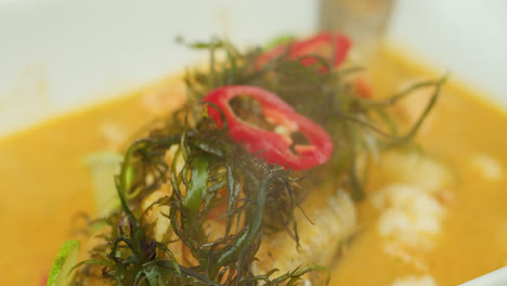 Amazing-slow-motion-and-zoom-in-shot-of-a-Peruvian-dish-with-fish-elegantly-served-on-a-white-plate-and-smoking