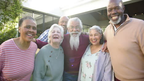 Portrait-of-happy-diverse-female-and-male-senior-friends-embracing-in-sunny-garden,-slow-motion