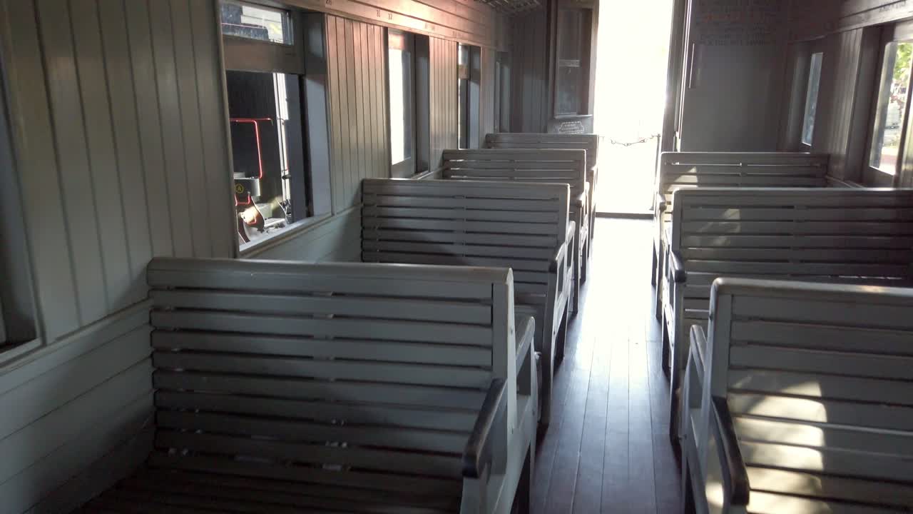 Camera zooms in through the interior of an old train wagon, cinematic depth and warm natural light from outside