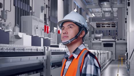 close up side view of asian male engineer with safety helmet looking around while standing at pharmaceutical factory, vaccine production facility