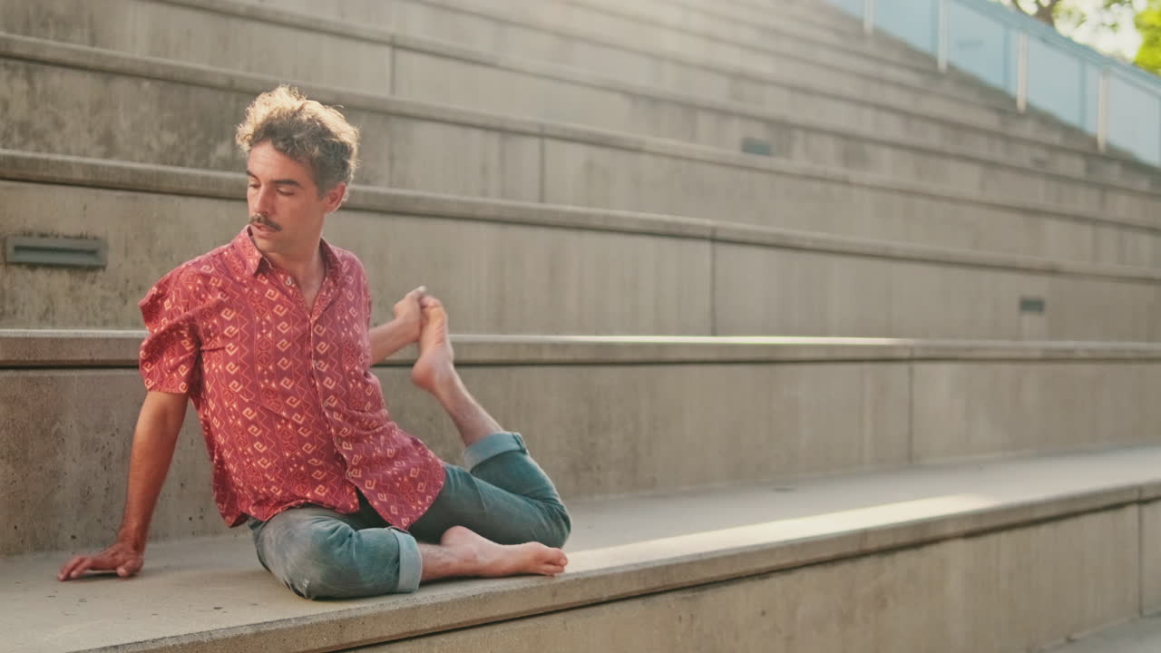 Man Performing Yoga Pose with Leg Extended on Concrete Steps