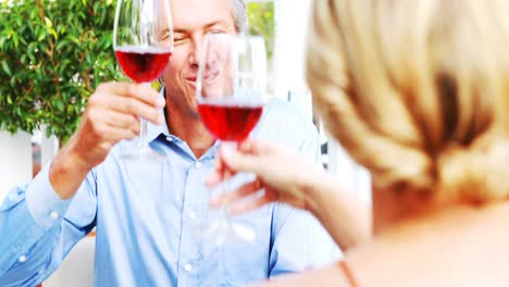 pareja brindando copas de vino mientras almuerzan en un restaurante