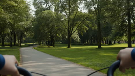pov bicycle ride on a path through a lush green park