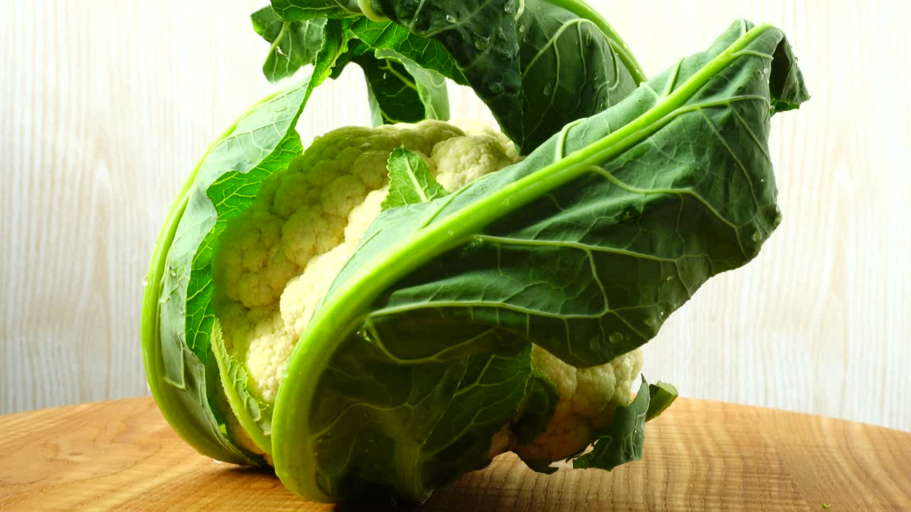 Shooting of cauliflower in the movement. Cuttig board