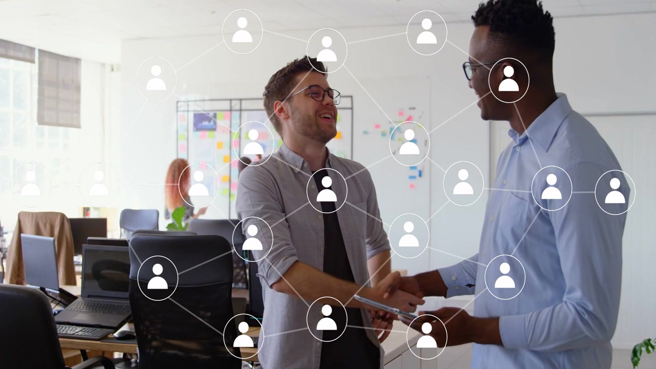 Two men reviewing tablet for business pointing causing network overlay over them then shaking hands
