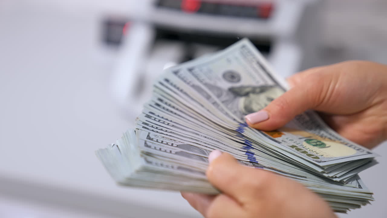 Female hands counting US Dollar bills. US national paper currency.