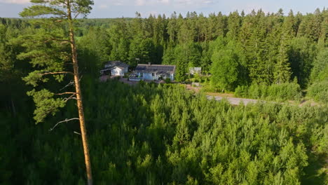 aerial pull back of a off-grid home with a renewable energy roof, summer evening