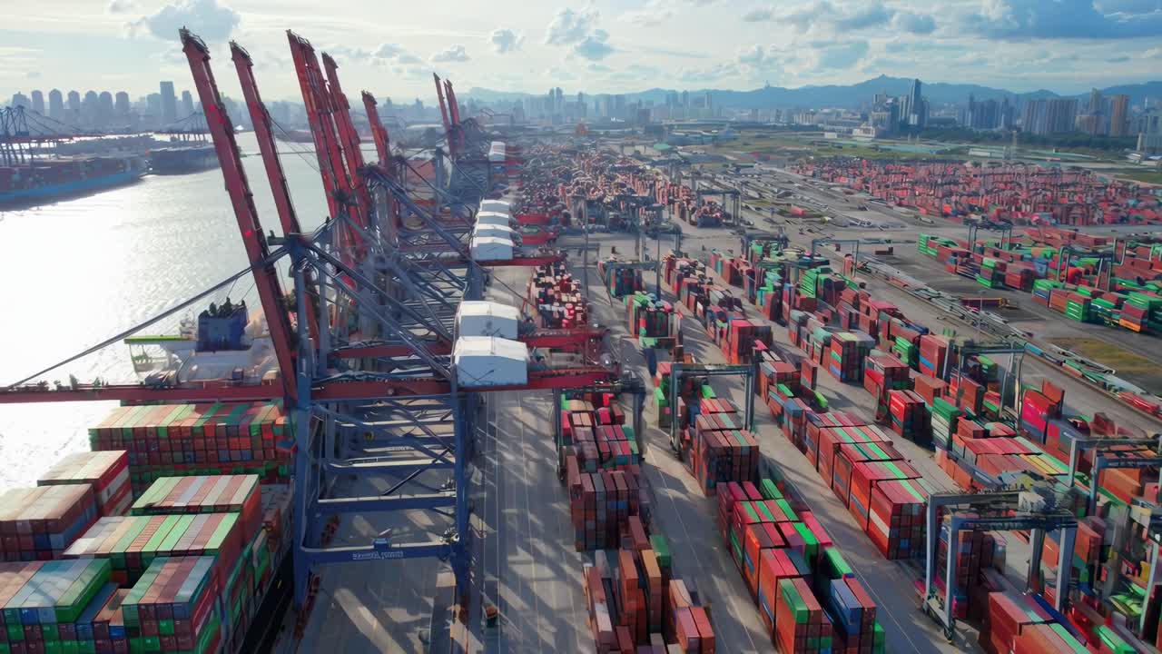 Ripresa aerea di un vivace porto con container e gru colorati, che mostra lo skyline urbano