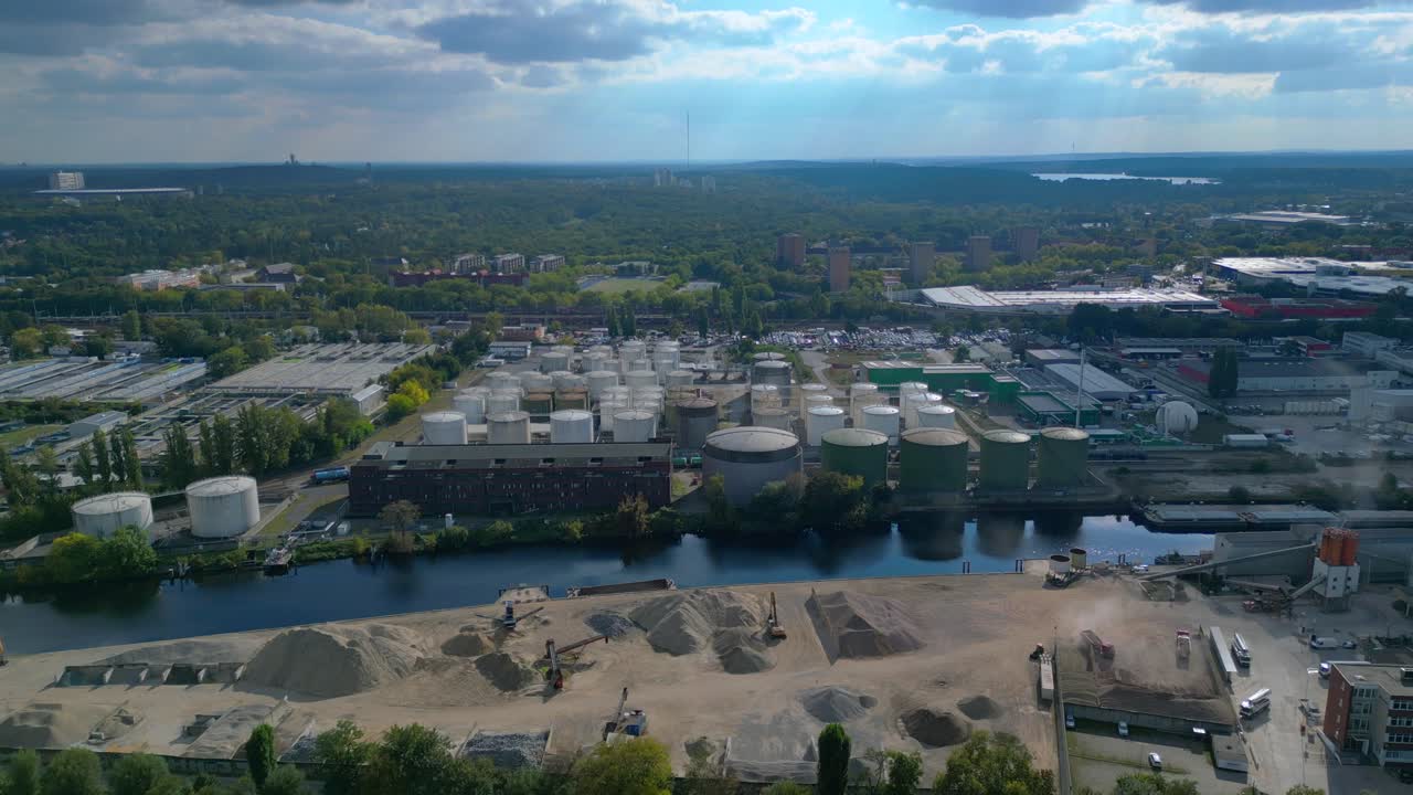 Berlin biogas plant with storage tanks by Spree river, producing renewable energy. Best aerial view flight ascending drone