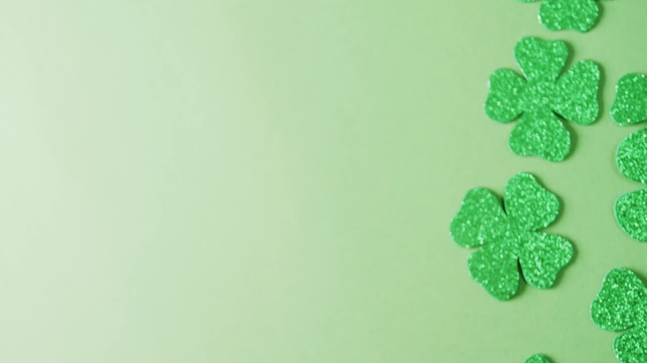 Video of st patrick's green shamrock leaves with copy space on green background