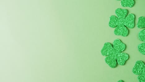 video of st patrick's green shamrock leaves with copy space on green background