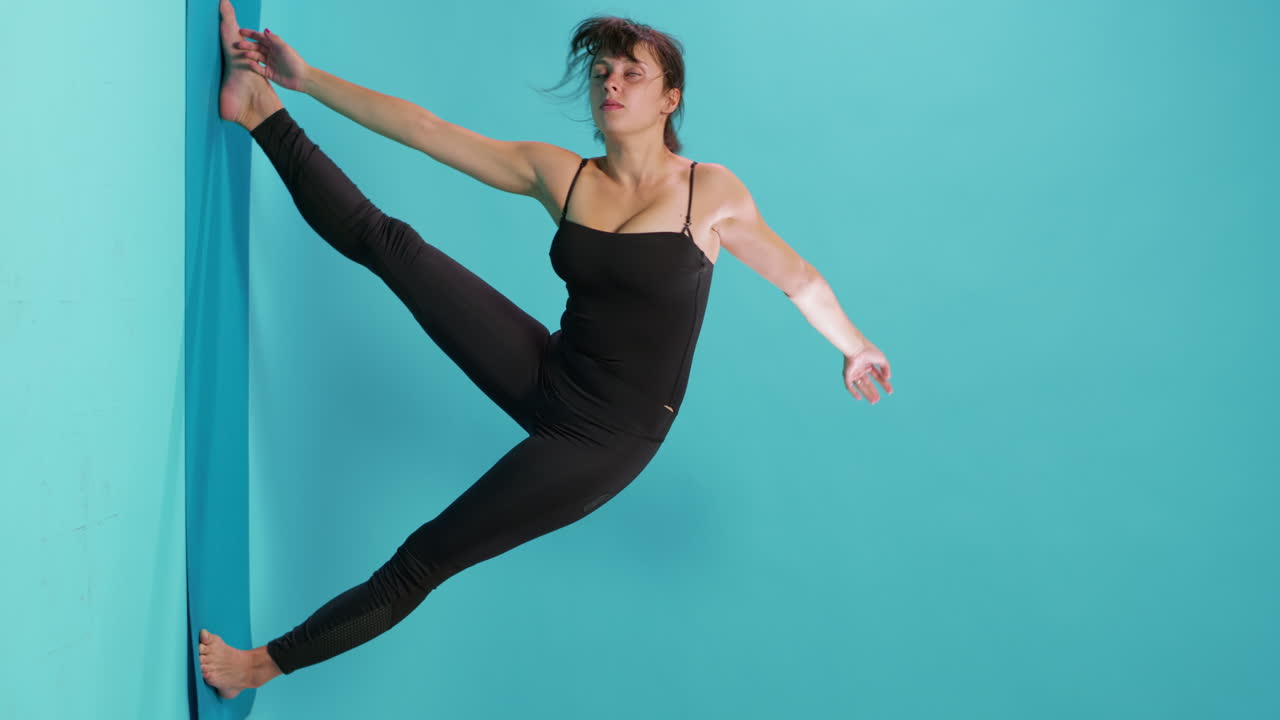 Woman finishing workout training in studio and stretching muscles