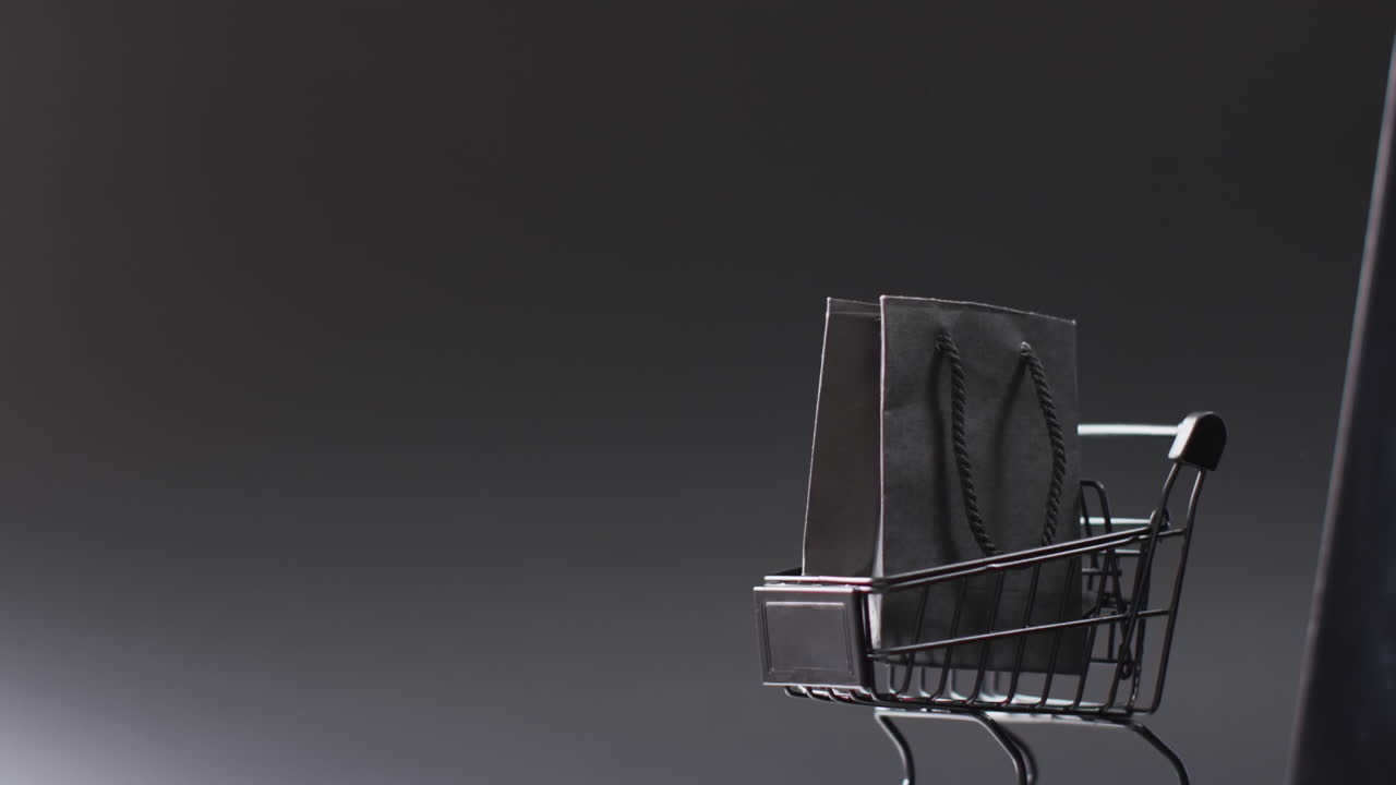 video de portátil con pantalla en blanco, bolsa de compras y carrito con espacio de copia sobre fondo blanco