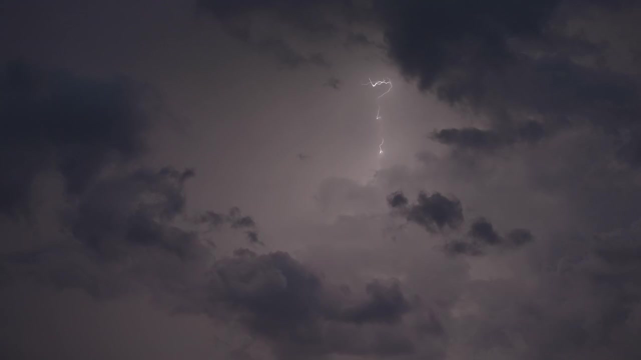 Fulmini atmosferici guizzano tra strati di nuvole scure e cupe