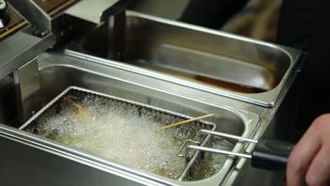 cooking fried shrimp skewers in a commercial fryer