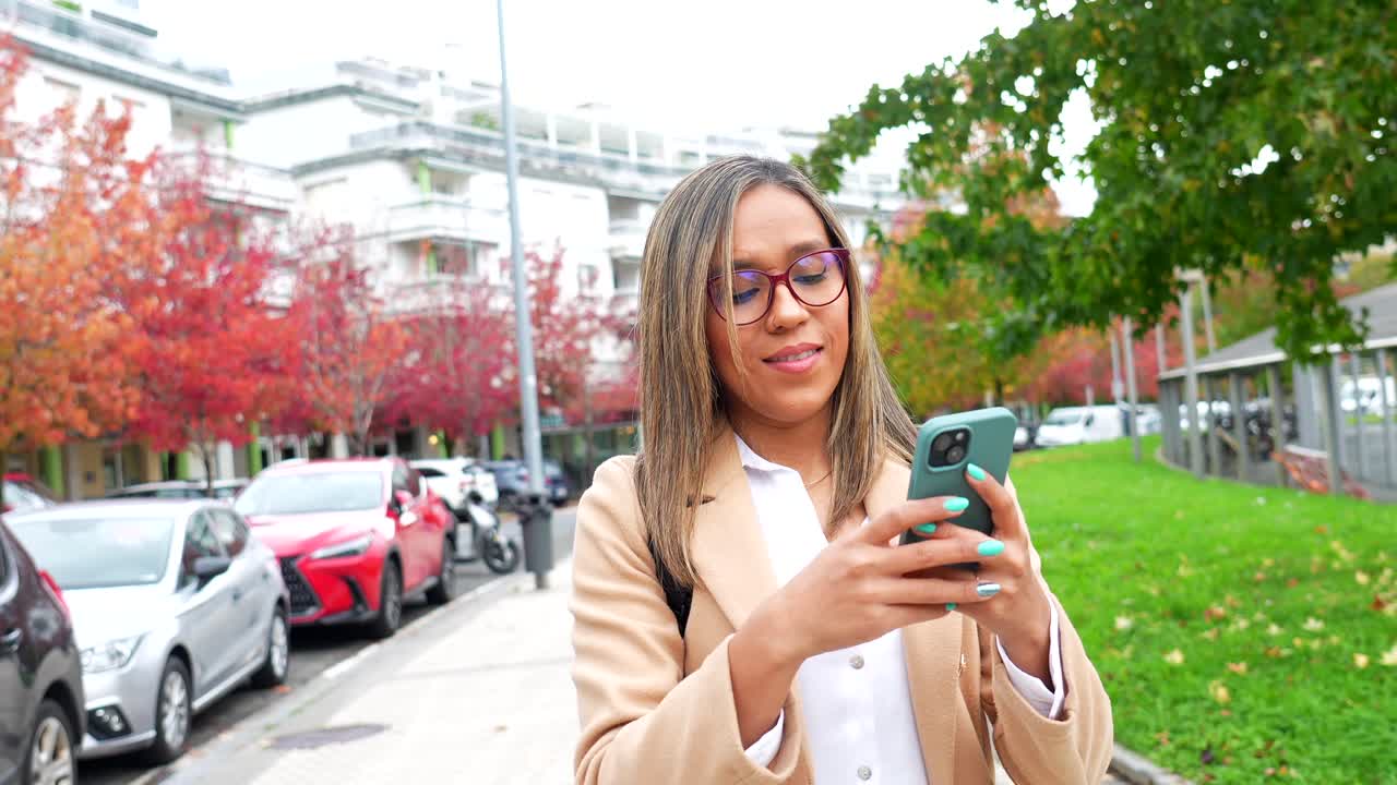 Woman using smartphone on the street in autumn