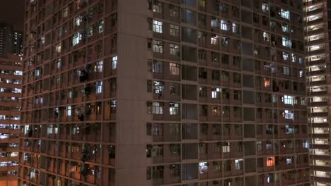 Una-Vista-Nocturna-De-Un-Edificio-De-Viviendas-Públicas-De-Gran-Altura-Lleno-De-Gente-En-Hong-Kong