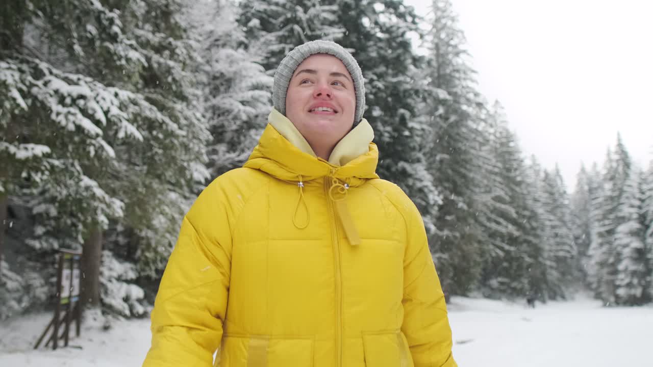 Woman in a yellow jacket in a snowy forest