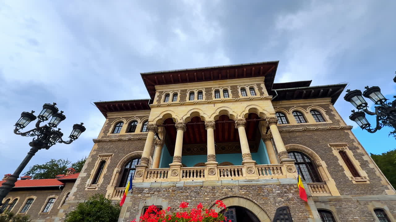 Busteni, Romania, 17 July 2025: Front façade of Cantacuzino Castle in Busteni, Romania. Famous landmark from low angle perspective against cloudy sky