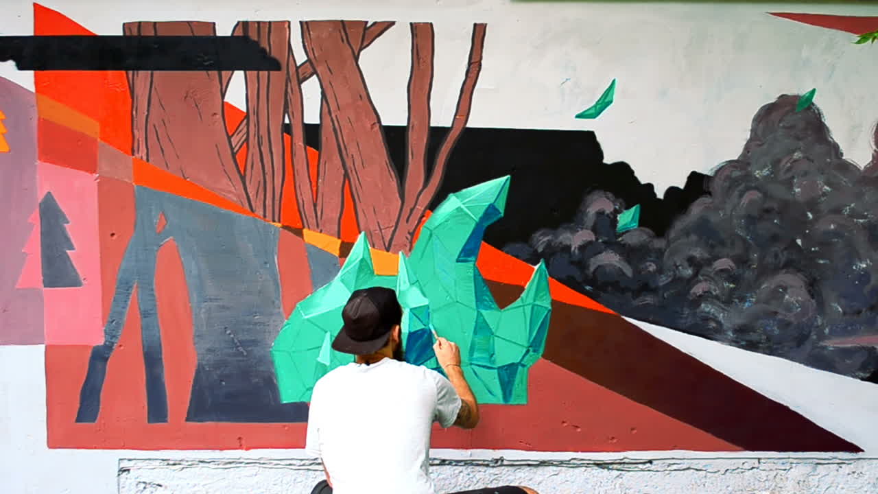 L'artista realizza graffiti su una recinzione. Disegno astratto