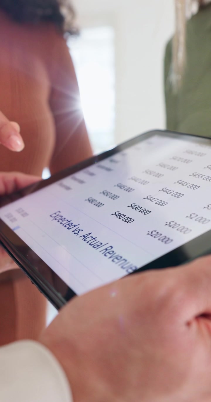 Business Colleagues Reviewing Financial Revenue Data on a Tablet