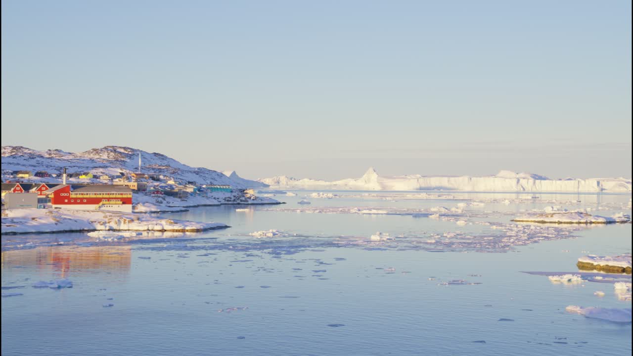 얼음과 바다의 해안선에 있는 빛이 비치는 도시