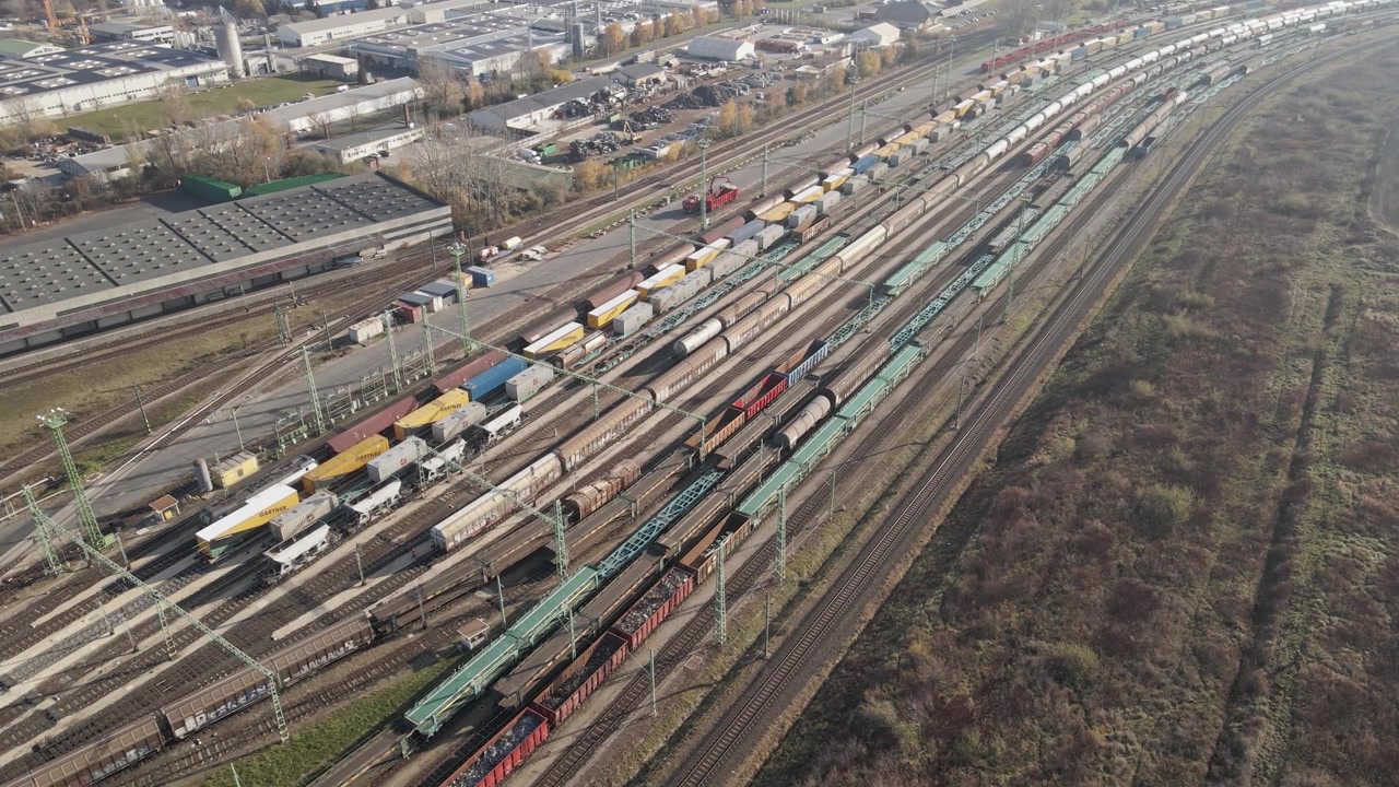 Luftvideo eines Güterbahnhofs mit mehreren Gleisen, während ein Zug am Bahnhof ankommt