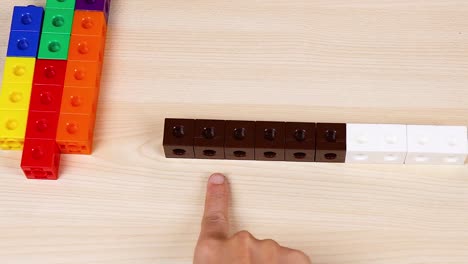 las manos manipulan coloridos cubos de enlace en la mesa