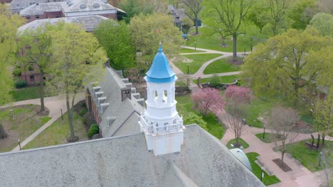 aerial of blue painted bellfry atop large building on american university campus in lancaster pennsylvania, usa