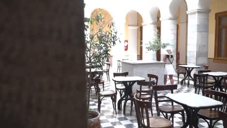 reveal shot of girl in dress and summer outfit walking through beautiful hall inside syros town hall