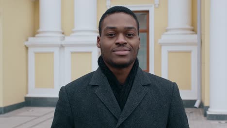 man smiling in front of a building