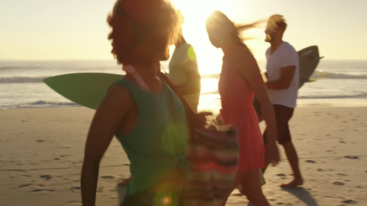 Young adult friends walking on a beach at sunset 4k