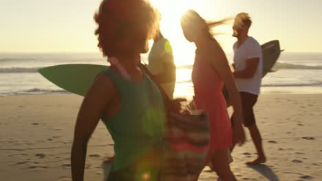 young adult friends walking on a beach at sunset 4k