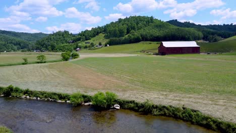 AERIAL-PUSH-OVER-WATAUGA-RIVER-TO-FARM-SETTING-IN-SUGAR-GROVE-NC,-NEAR-BOONE-AND-BLOWING-ROCK-NC,-NORTH-CAROLINA