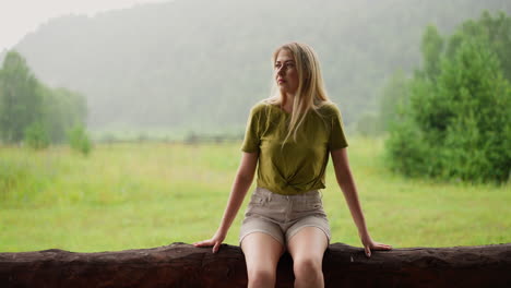 thoughtful lady enjoys nature beauty sitting on log fence