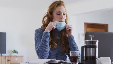 Woman-wearing-face-mask-drinking-coffee-at-home