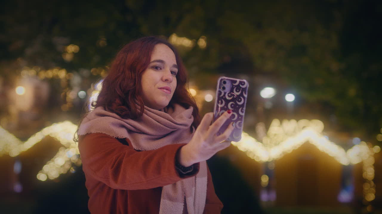 ragazza che prende un selfie con il suo smartphone in un mercato di natale gimbal slow motion shot