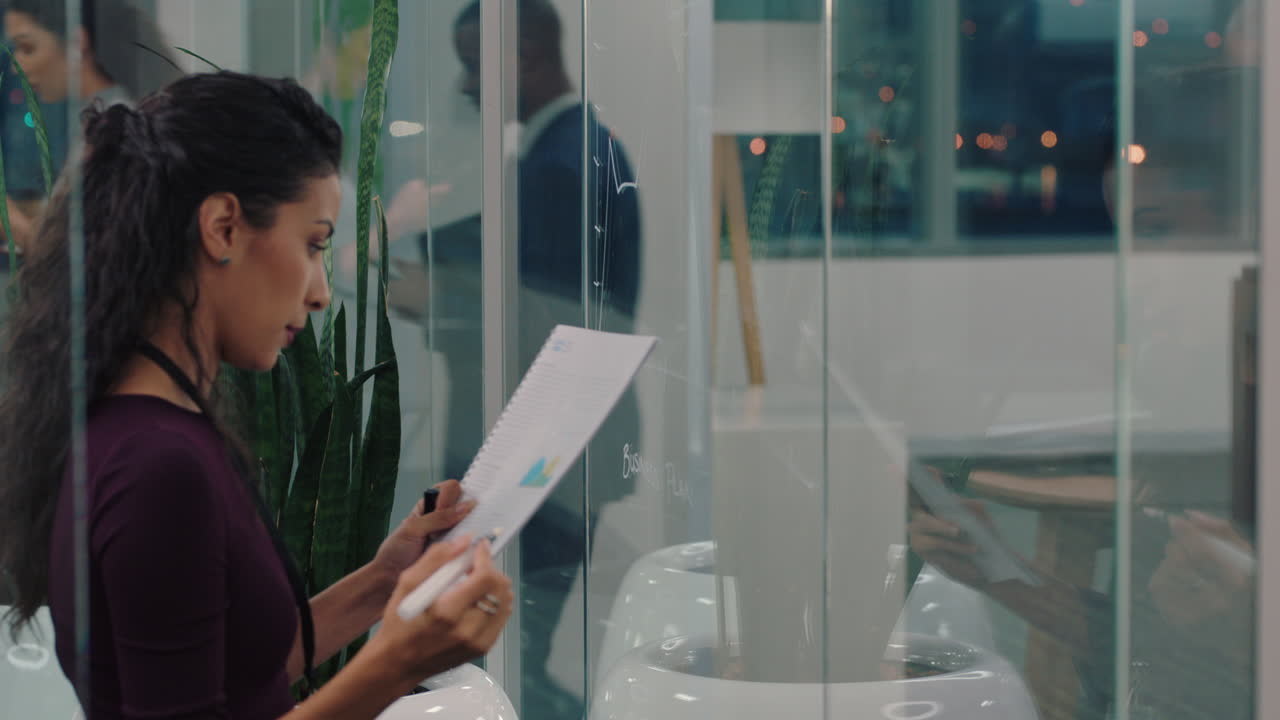 business woman writing on glass whiteboard female project manager brainstorming sales strategy using marketing data working late in office