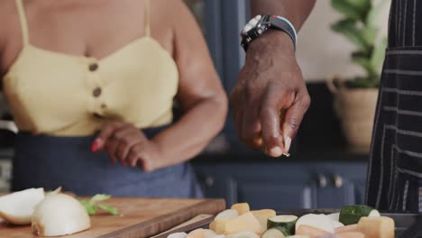 una pareja afroamericana de alto nivel cocinando en la cocina en cámara lenta