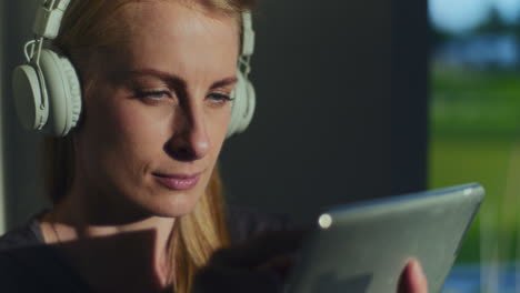 pensive woman while reading a book on a digital tablet