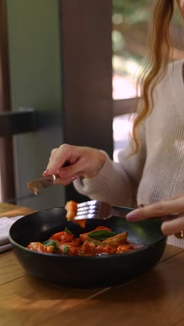 woman eating pasta dish