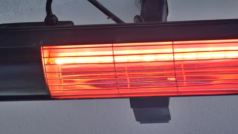 a red infrared heater mounted on a white wall