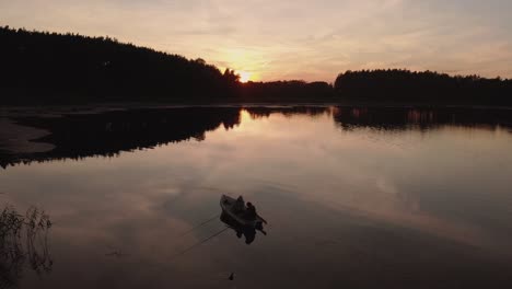 Couple-Sitting-On-The-Boat-Enjoying-The-Quiet-And-Serene-Lake-During-A-Golden-Hour-On-Sunset-In-Rogowko,-Poland