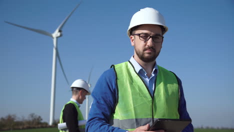engineer inspecting wind turbines at a wind farm.