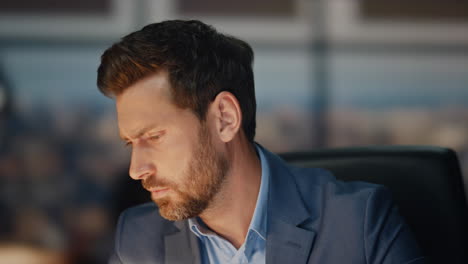 pensive employee working night office closeup. tired businessman in lamp light
