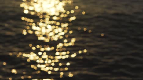 morning sun reflects on sea surface, out of focus footage creating nice yellow bokeh balls, abstract natural background