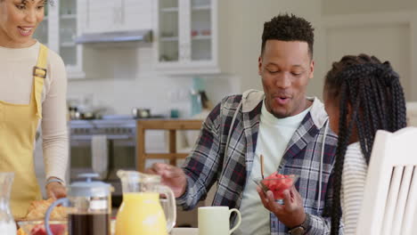 Felices-Padres-Afroamericanos-E-Hija-Desayunando-En-La-Mesa,-Cámara-Lenta